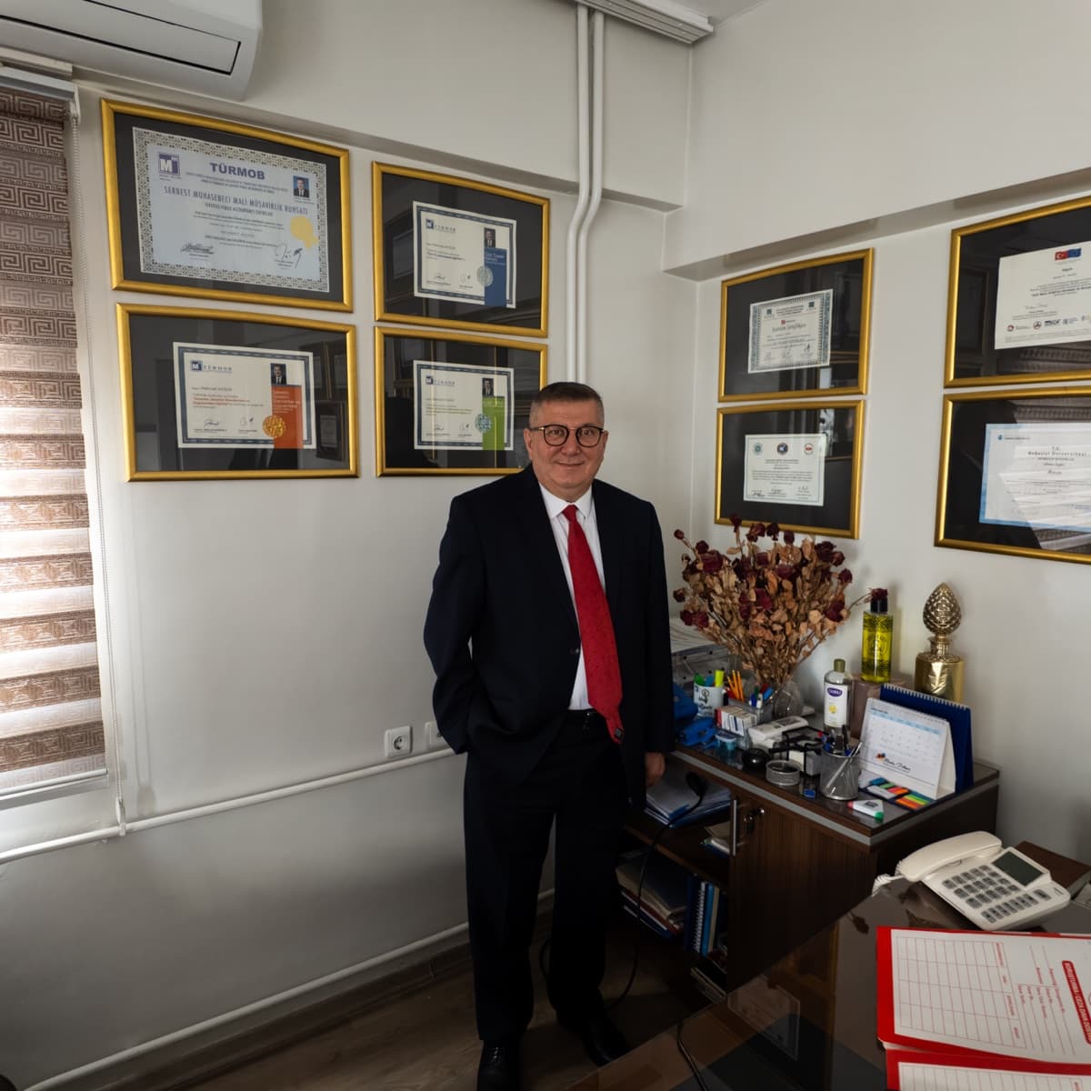 May Kurumsal kurucusu Mehmet Aygün, ofisinde TÜRMOB ve SMMM mali müşavirlik belgeleri önünde